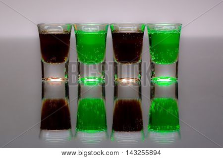 Four cups of alcohol to drink on grey nackground