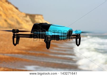 Flying drone with mounted camera on the beach