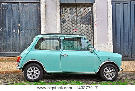 LISBON - DECEMBER 25 2012: Old fashioned light blue Mini in the street of Lisbon on December 25 2012. The Mini is a small cars made by the British Motor Corporation.