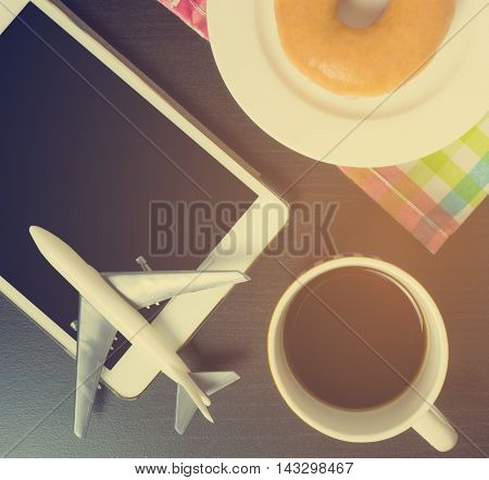 Traveling planning in a cafe table. Vacation planning on tablet while having coffee break. Internet tablet booking for vacation.