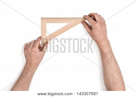Man holding a wooden set square or right angle in the 90-60-30 conformation over a white background with copy space in a conceptual image , overhead view of his arms