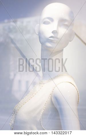 Store window fashion retail shop female mannequin bald dummy.