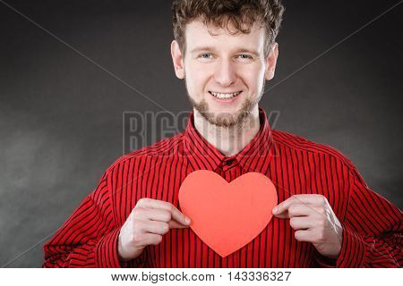 Love and help from people. Charming lovely man with red paper heart persuade to be good helpful hopeful. Valentines Day or charity concept.