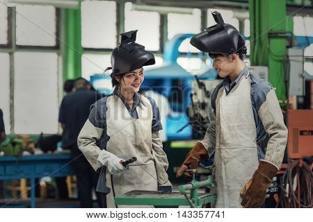 Industrial welder man and woman worker at factory