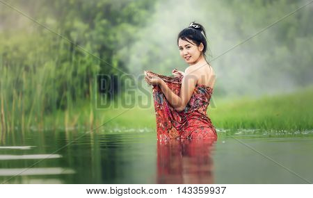 Thai Woman bathing in the river, Thailand