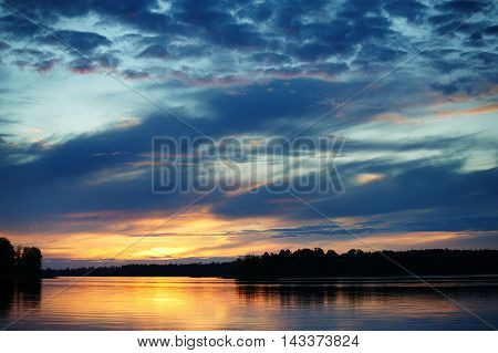 Sunset on the lake Vuoksa Russia with dark clouds