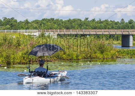 Fisherman in Kayak with umbrella Minocqua Wisconsin