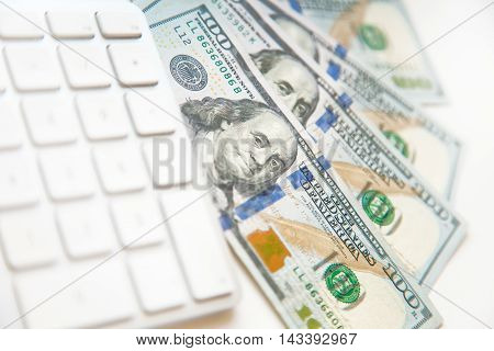 Concept image of finance and investment. 100 US dollars bank notes with computer keyboard.