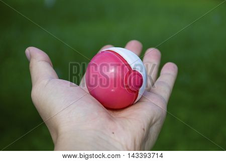 Thailand - August 20, 2016: Poke ball in Hand  (Pokemon Ball). Pokeball toy of the game Pokemon Go at Chon Buri, Thailand.