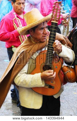 Cajamarca Peru - February 8 2016: Andean man with sombrero plays guitar in Carnival parade in Cajamarca Peru on February 8 2016
