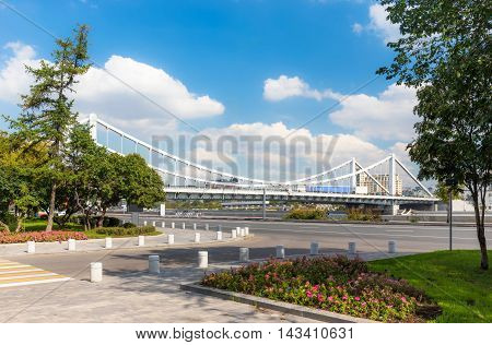 Krymsky Bridge in Moscow Russia with plants on a foreground. View from Frunzenskaya embankment.