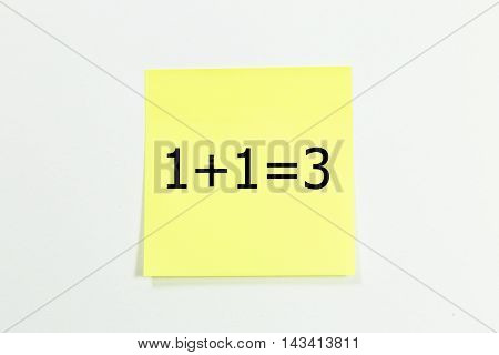 1+1=3 word written on yellow sticky notes. isolated on White.Business concept.