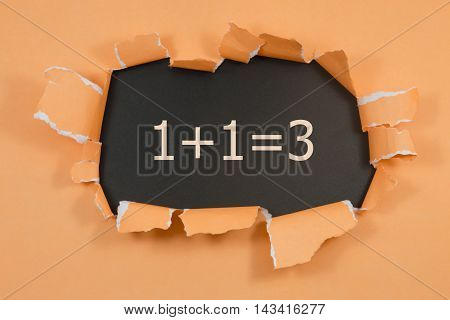1+1=3 written under torn orange paper.Business, technology, internet concept