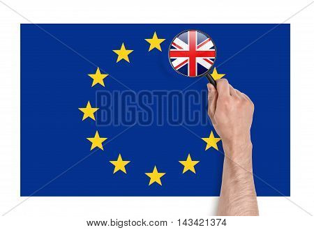 Top view of a man's hand holding a magnifier over EU flag with magnified flag of UK. Brexit. British withdrawal. Significant decision. Substantial choice.