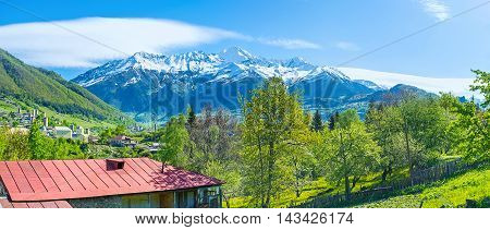 The snowbound peaks of Caucasus mountains from the green valley ocuupied by townlets and villages with the medieval towers of Mestia on the distance Svaneti Georgia.