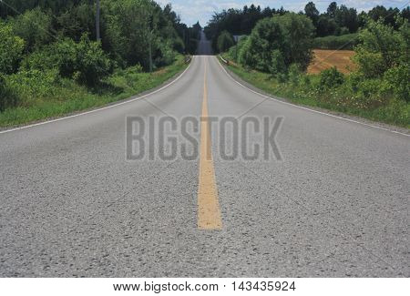 Country tarmac road meandering through hilly farm country