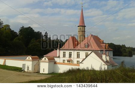 old building with white walls and high red spire