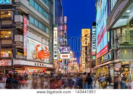 OSAKA, JAPAN - NOVEMBER 25, 2012: Crowds walk below the signs of Dotonbori. With a history reaching back to 1612, the district is now one of Osaka's primary tourist destinations.