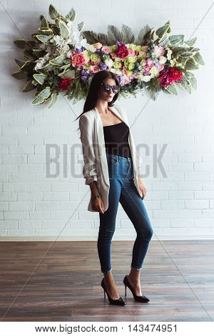 Model, woman in fashionable jeans and a jacket in full length in Studio on a light background