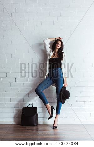 Model, woman in fashionable jeans and a jacket in full length in Studio on a light background