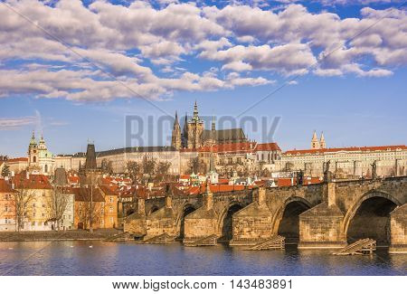 Charles Bridge under a cloudy sky - Cityscape with St. Vitus Cathedral in background and the Charles Bridge in foreground, under a beautiful sky. Picture captured in Prague, Czech Republic