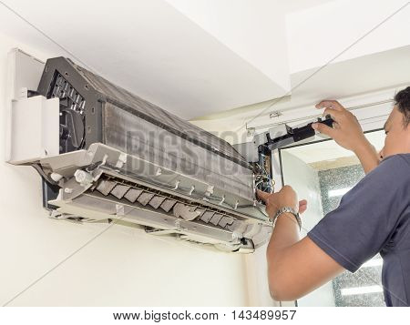 Single electrician man clean fix and maintain air conditioning in the house