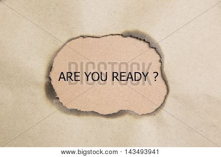 The question Are You Ready appearing behind torn brown paper