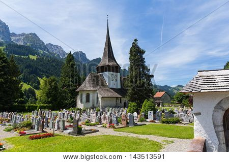 Church with wooden roof and cemetery in Rougemont Vaud canton of Switzerland