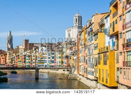 Onyar river crossing the downtown of Girona with bell tower of Basilica of Sant Feliu and Santa Maria cathedral in background. Gerona Costa Brava Catalonia Spain.