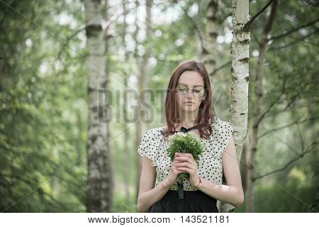 Portrait of young girl walking in the forest Birch Grove birch green yellow forest in summer spring warm autamn. Some trees in focus and some in bokeh. Light color soft grass