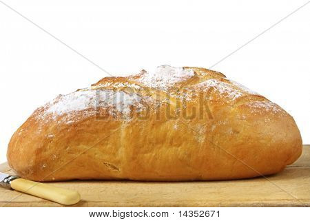 Bochník chleba na desce chleba, připraven k použití.