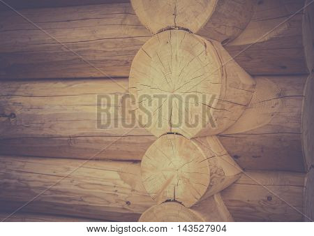 Log house corner details - Architectural image with the exterior corner and part of the wall of a log house, traditional built from round wooden beams.
