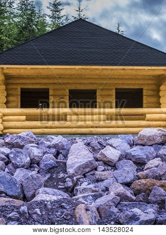 Wooden cabin and stone - Rustic wooden cabin made from beams with a shingle roof, having in front of it a stone slope