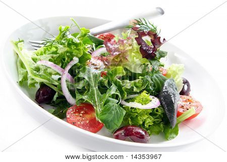 Semplice insalata di giardino in una ciotola bianca, con forcella.