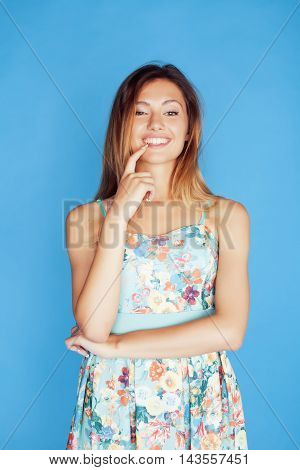 young pretty adorable woman close up like doll posing, natural makeup emotional gesturing on blue background