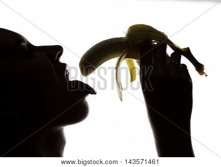 Young amazed woman in lacy lingerie holding a banana, she is going to eat a banana. she sucks a banana.