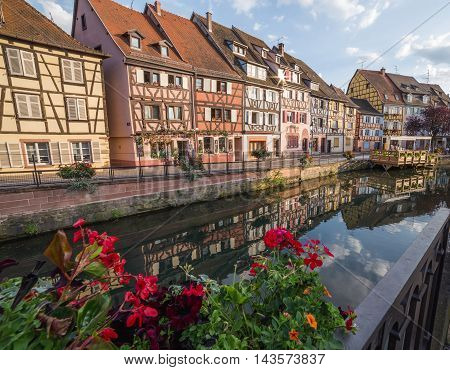 COLMAR FRANCE - 30TH JULY 2016: A view of colourful timber framed buildings along Little Venice in Colmar during the morning. Reflections can be seen in the River Lauch