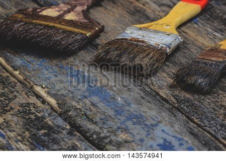Old and dirty brushes on woood background