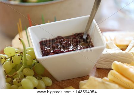 small square bowl with home made sour cherry preserves on a table