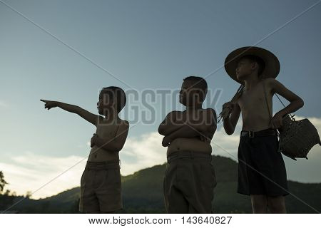 Silhouette of three boys The fishermen in the countryside
