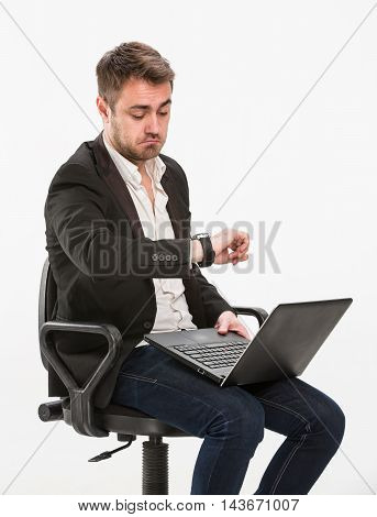 a hurry, bewilderment, chair, clerk, confusion, deadline, delay, despair, emotion, fear, haste, holding, laptop, limit, looking at his watch, looks surprised, male, man, manager, office, office worker, panic, rush, shock, sitting, student, studio, thinkin