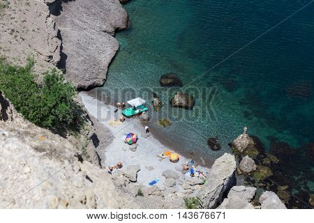 Active rest on the rocky coast in the summer. Clear water
