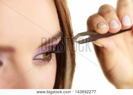 Make up and cosmetics. Woman plucking eyebrows depilating with tweezers. Attractive girl tweezing eyebrows