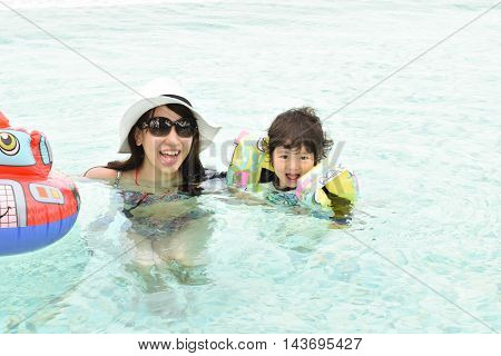 mother and son playing at pool during summer vacation