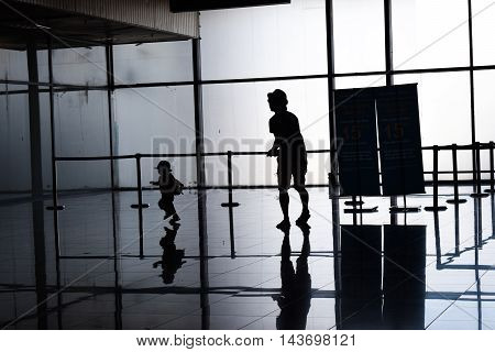 parent and kid running at air port shadow light