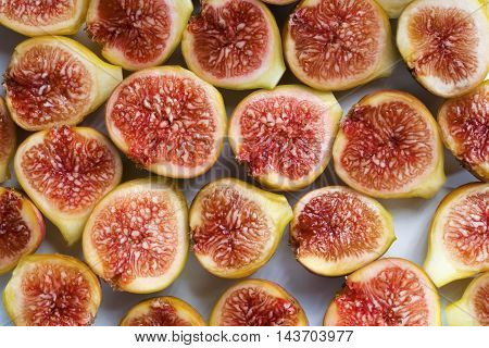 Background filled with fresh sliced figs. Close-up