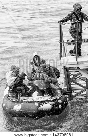 SOUTH GEORGIA, GREAT BRITAIN - NOV 9, 2012: Unidentified group of people in a water proof suit in a rubber boat with a motor in the Atlantic Ocean. Atlantic Ocean is the world's second largest ocean