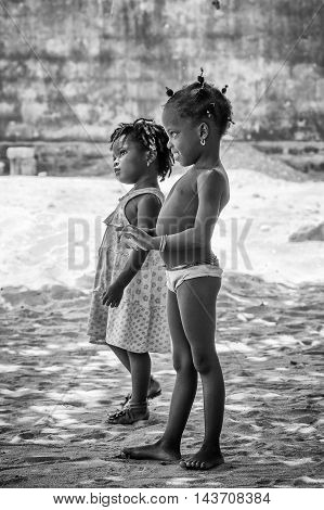 KARA, TOGO - MAR 9, 2013: Unidentified Togolese girls walk in the street. Children in Togo suffer of poverty due to the unstable econimic situation