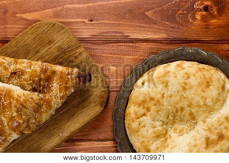Traditional Uzbek bread and samosas on wooden background