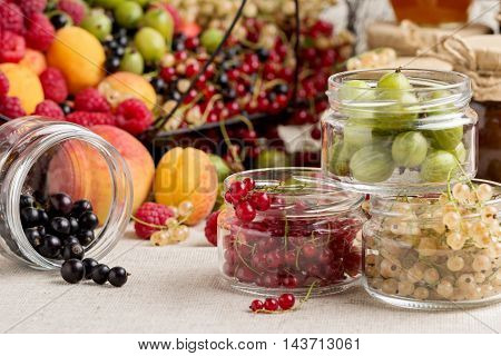 Summer fruits and berries - red black and white currants raspberries gooseberries peaches and apricots. Selective focus.